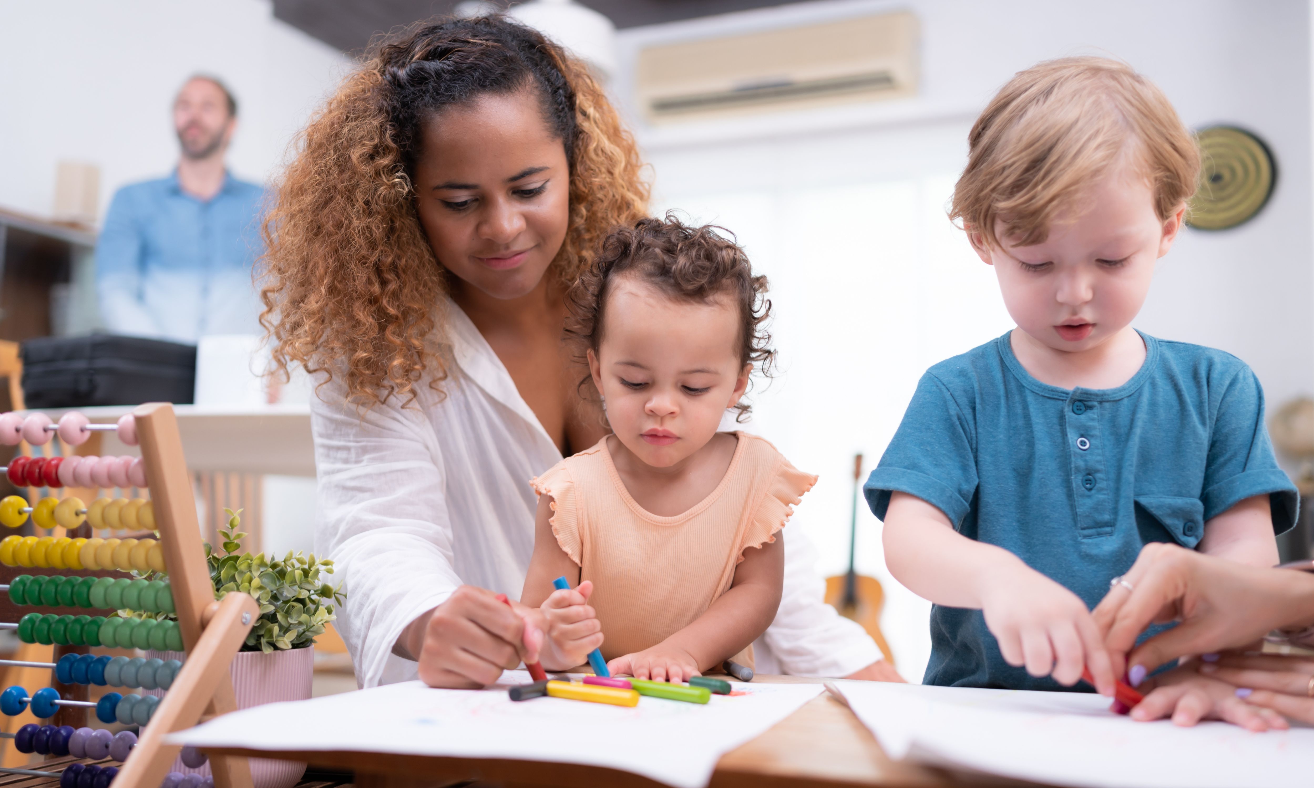 Children mark making with support from early years carers