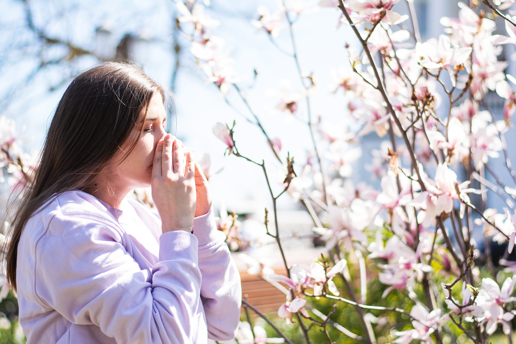 Woman suffers from seasonal allergy outside in the sunshine